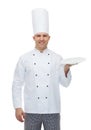 Happy male chef cook showing empty plate Royalty Free Stock Photo