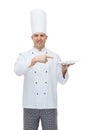 Happy male chef cook showing empty plate Royalty Free Stock Photo