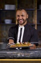 happy male chef presenting the dish in commercial kitchen Royalty Free Stock Photo