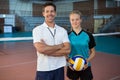 Happy male coach and volleyball player standing in the court Royalty Free Stock Photo