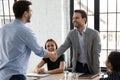 Happy male colleagues handshake closing deal in office Royalty Free Stock Photo