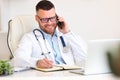 Happy male doctor consulting patient by phone call while working in hospital Royalty Free Stock Photo