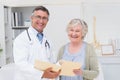 Happy male doctor and female patient with reports Royalty Free Stock Photo