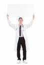 Happy male doctor holding empty placard over his head Royalty Free Stock Photo