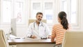 Happy male doctor talking to female patient in clinic Royalty Free Stock Photo