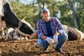 Happy male farmer on cow farm around herd .