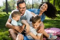 Happy male and female playing and enjoying picnic with children outside Royalty Free Stock Photo