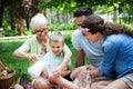 Happy male and female playing and enjoying picnic with children outside Royalty Free Stock Photo