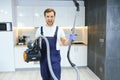 Happy Male Janitor Cleaning Carpet With Vacuum Cleaner Royalty Free Stock Photo