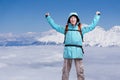 Happy male mountaineer man with raised arms. In background high mountains above clouds . Royalty Free Stock Photo