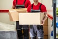 Happy Male Movers Holding Cardboard Boxes Royalty Free Stock Photo