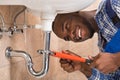 Happy Male Plumber Repairing Sink In Bathroom Royalty Free Stock Photo
