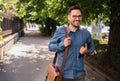 Happy professional with digital tablet looking away while walking on sidewalk Royalty Free Stock Photo