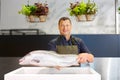 Happy male seller holding trout at fish shop