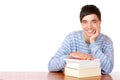 Happy male student on desk with books Royalty Free Stock Photo