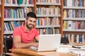 Happy Male Student With Laptop In Library Royalty Free Stock Photo