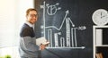 Happy male student, teacher, freelancer with chalk at blackboard Royalty Free Stock Photo