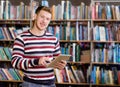 Happy male student using a tablet computer in a library Royalty Free Stock Photo