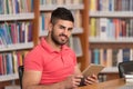 Happy Male Student Working With Laptop In Library Royalty Free Stock Photo