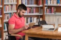 Happy Male Student Working With Laptop In Library Royalty Free Stock Photo