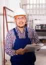 Male surveyor in coverall doing checkup and filling papers