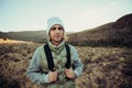 Happy male teen hiking in luscious mountain dressed warmly reading to exercise