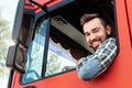 Happy male truck driver inside his red cargo truck Royalty Free Stock Photo