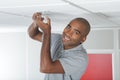 happy male worker changing light bulb