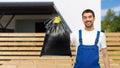 happy male worker or cleaner showing garbage bag