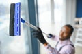 Happy Male Worker Cleaning Glass With Squeegee And Spray Bottle Royalty Free Stock Photo