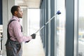 Happy Male Worker Cleaning Glass With Squeegee And Spray Bottle Royalty Free Stock Photo