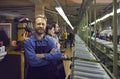 Happy male worker standing in shoe manufacturing workshop at footwear making factory