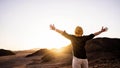 Happy man with arms outstretched standing on the top of the mountain enjoying sunset - Successful traveler with hands up Royalty Free Stock Photo