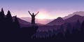 Happy man with arms raised stands on top of a cliff in mountain landscape at sunrise Royalty Free Stock Photo