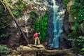 Silhouette traveller man explore waterfall hidden in tropical rainforest jungle Royalty Free Stock Photo