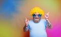 Fat happy man with beard, tattoos and sunglasses dances music on a disco