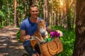 Happy man on bike with his dog in basket and tulips in the park. Royalty Free Stock Photo