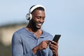 Happy man with black skin listening to music on phone Royalty Free Stock Photo