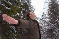 Happy man breathing fresh air in the forest during a walk