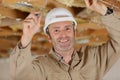 Happy man in builder uniform installing suspended ceiling