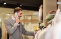 Happy man calling on smartphone at clothing store Royalty Free Stock Photo