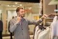 Happy man calling on smartphone at clothing store Royalty Free Stock Photo