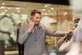 Happy man calling on smartphone at clothing store Royalty Free Stock Photo