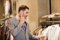 Happy man calling on smartphone at clothing store Royalty Free Stock Photo