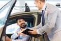 Happy man with car dealer in auto show or salon Royalty Free Stock Photo