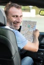 happy man in car with paper roadmap Royalty Free Stock Photo