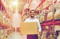 Happy man with cardboard parcel box at warehouse