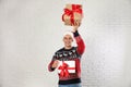 Happy man in Christmas sweater and Santa hat holding gift boxes near brick wall Royalty Free Stock Photo