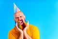 happy man with colorful beard wear horn on head in blue studio background