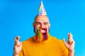 happy man with colorful beard wear horn on head in blue studio background
